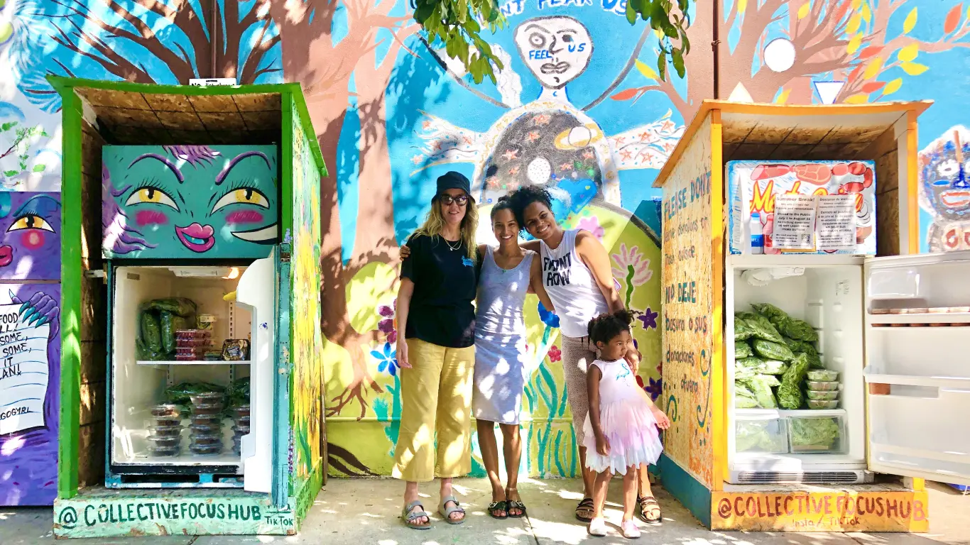 Volunteers in front of a community fridge